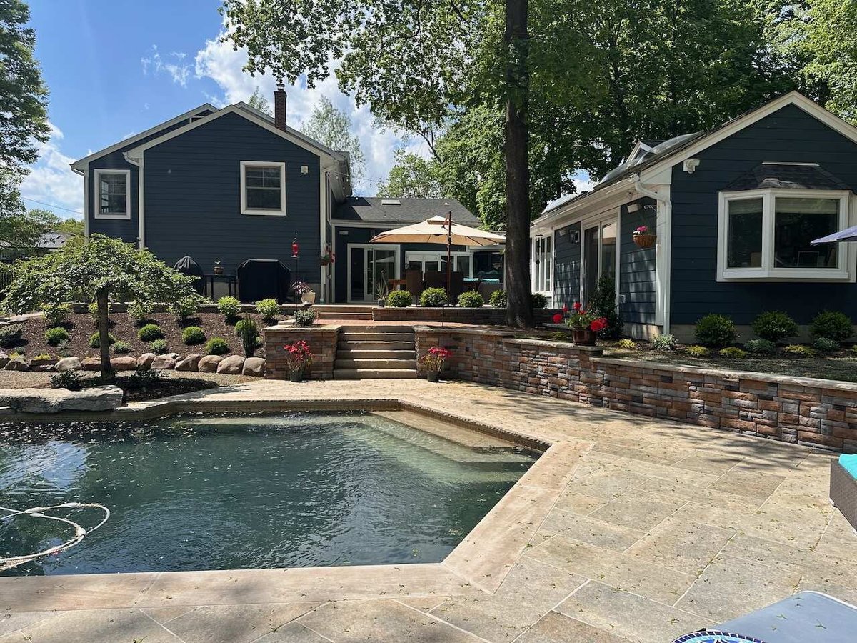 Overview of custom pool, tiered landscaping, and backyard retreat in Ridgewood, NJ by Fairmount Heights Homes.