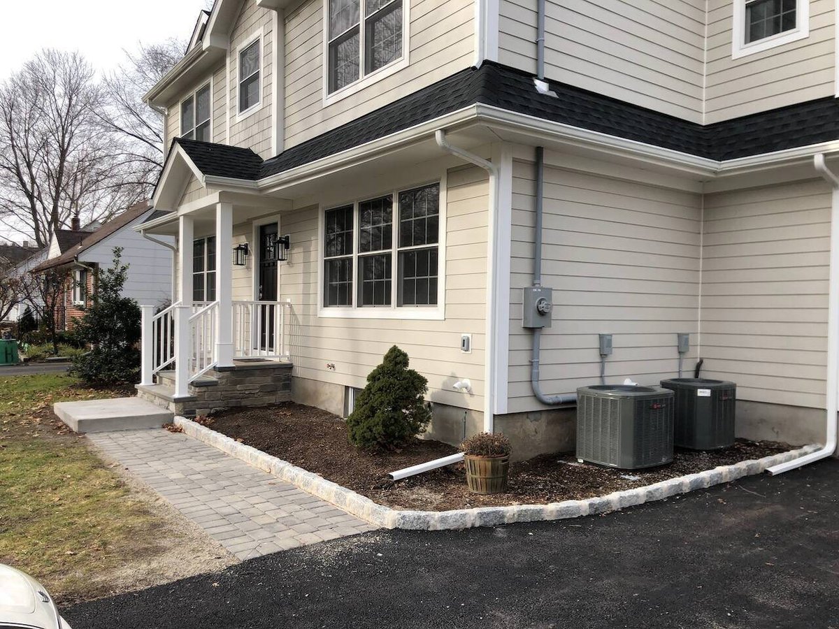 Angled view of Fairmount Heights Homes custom home entry with fresh landscaping in Ridgewood, NJ.