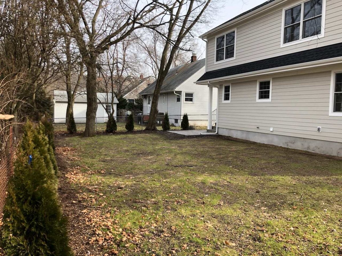 Backyard view showing custom home and new landscaping by Fairmount Heights Homes in Ridgewood, NJ.