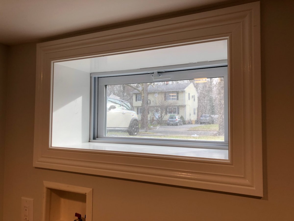 Basement egress window with trim and exterior view in Ridgewood home by Fairmount Heights Homes.