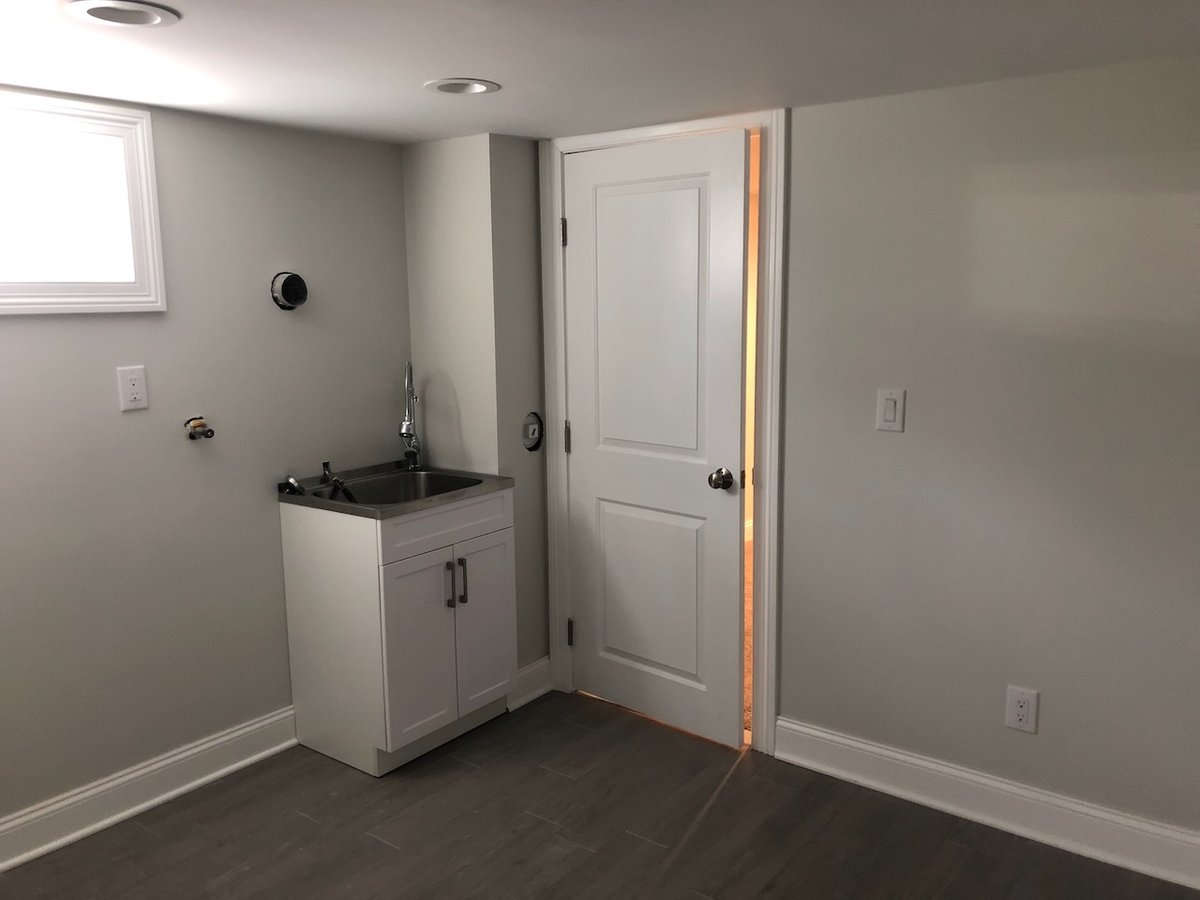 Basement laundry area with utility sink in Ridgewood custom home by Fairmount Heights Homes.