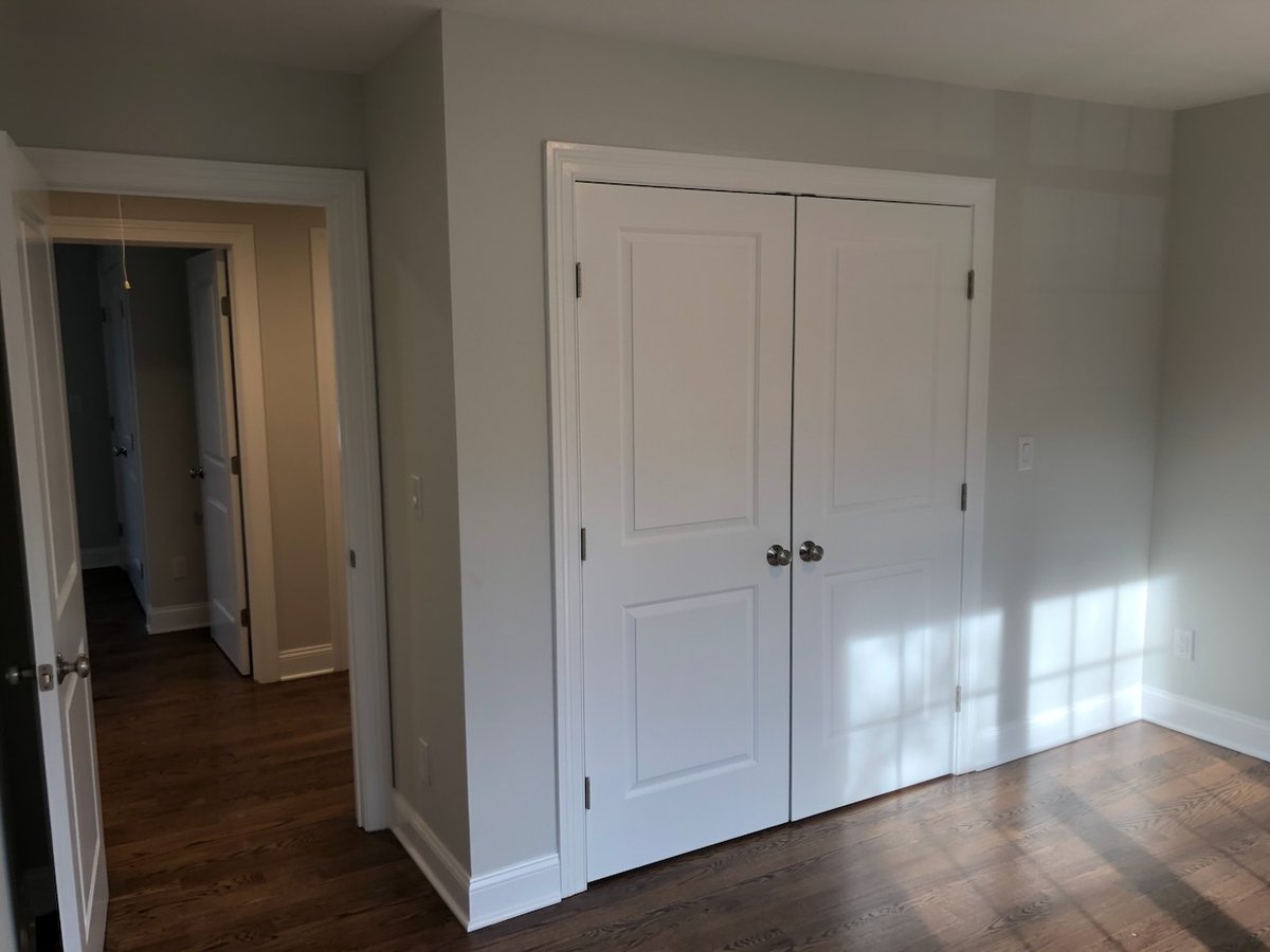 Bedroom with double closet doors and hallway view in Ridgewood custom home by Fairmount Heights Homes.