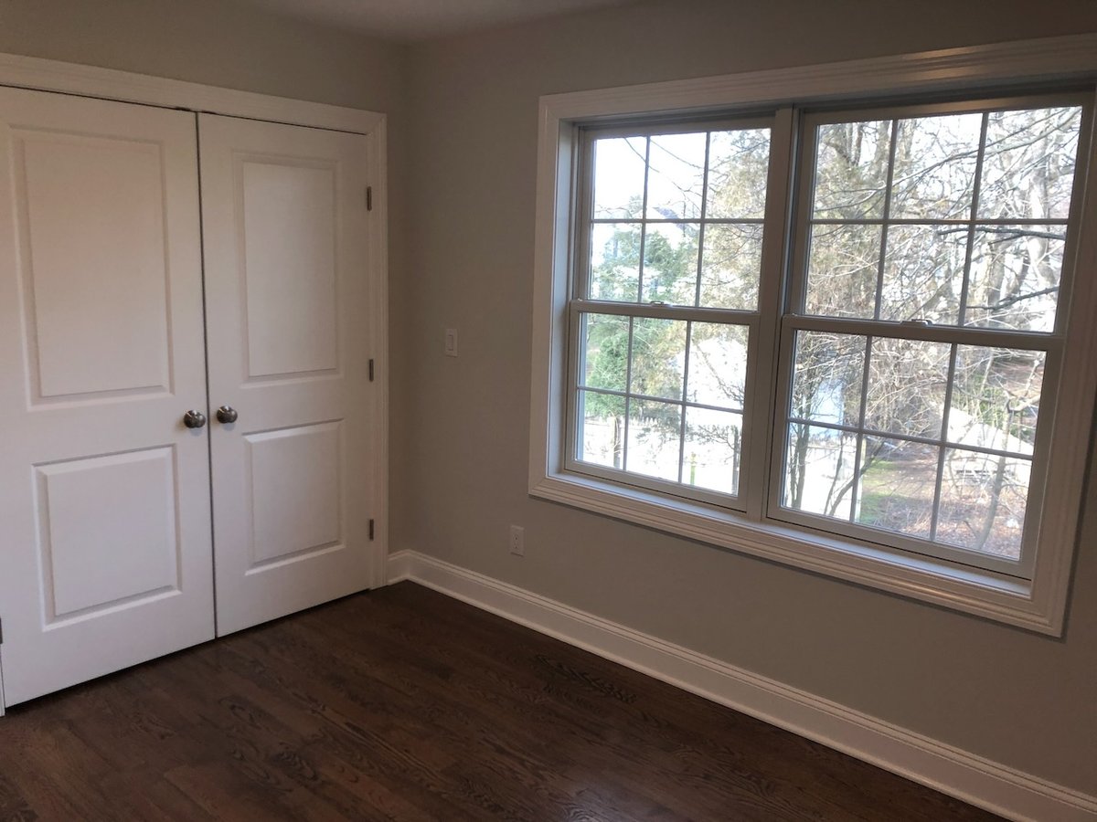 Bright bedroom with large window and closet in Ridgewood, NJ by Fairmount Heights Homes.