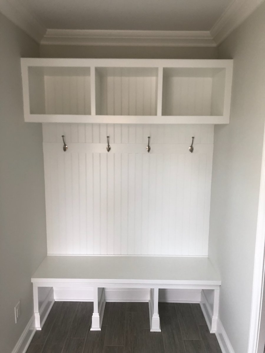 Built-in mudroom bench with cubbies and coat hooks in Ridgewood home by Fairmount Heights Homes.