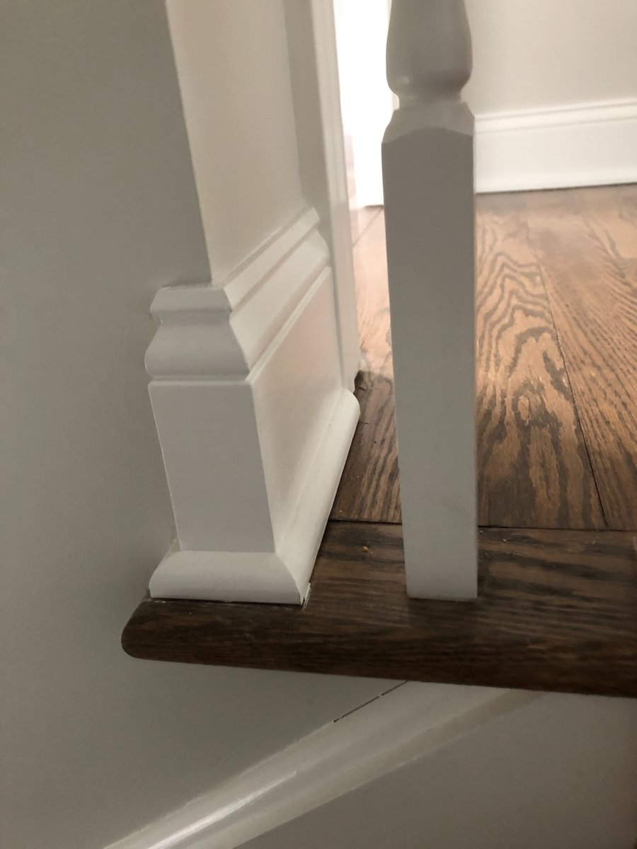 Close-up of stair post base and white trim detailing in a custom home by Fairmount Heights Homes in Ridgewood, NJ.