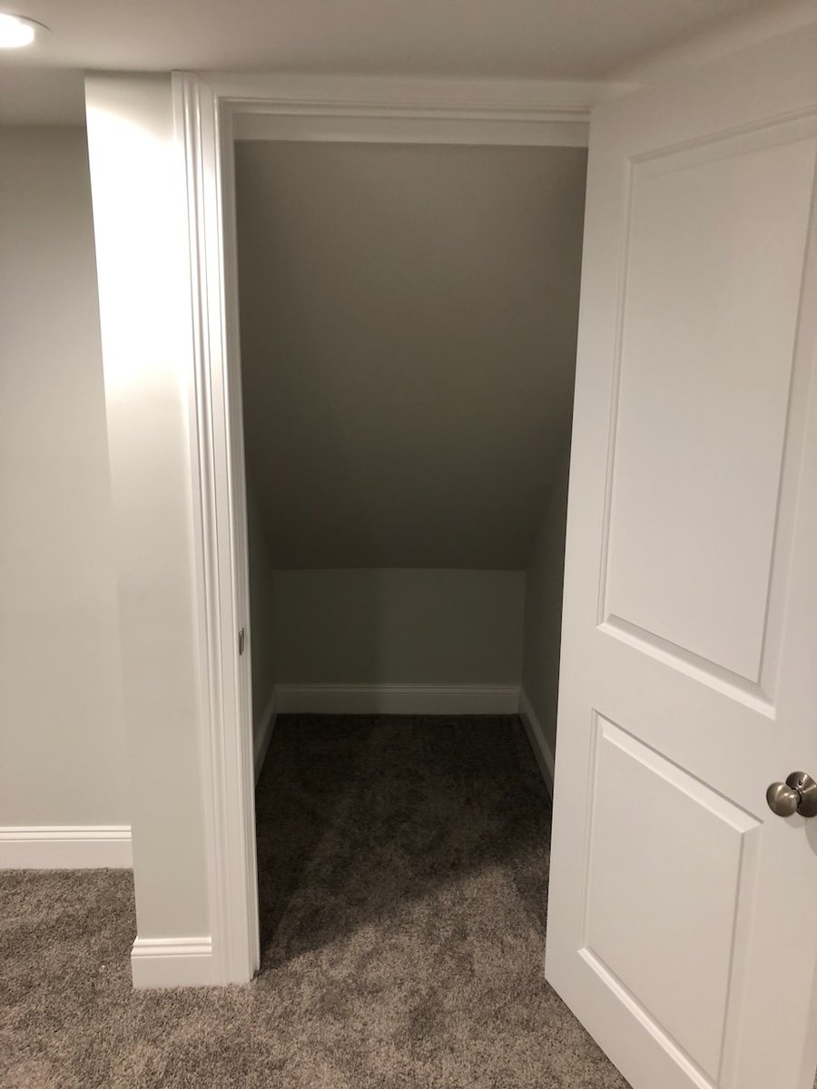 Closet under stairwell in finished Ridgewood basement by Fairmount Heights Homes.