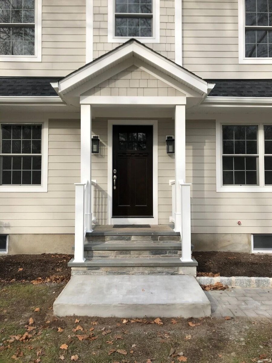 Concrete entry steps and paver walkway leading to custom front porch in Ridgewood, NJ by Fairmount Heights Homes.