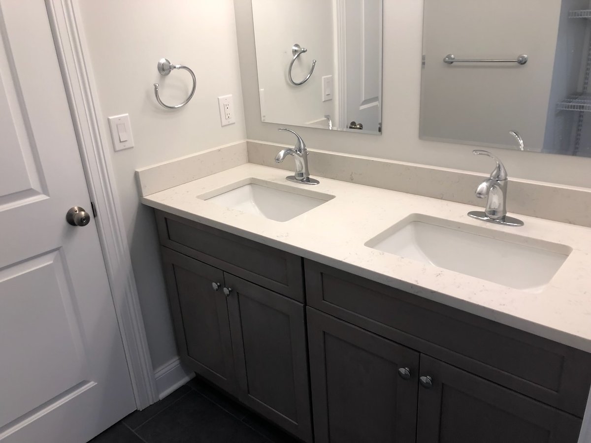 Double sink vanity with quartz countertop in Ridgewood custom bathroom by Fairmount Heights Homes.