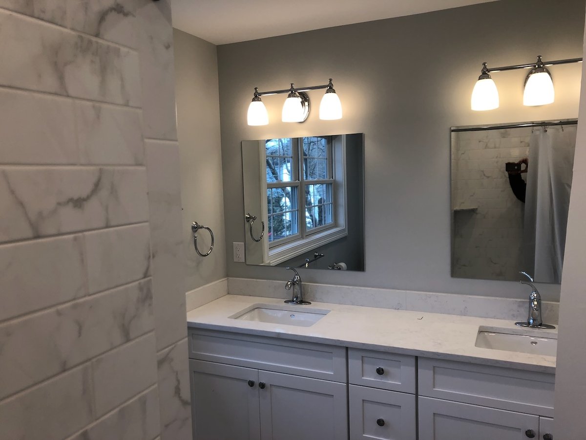 Double vanity with framed mirrors in a Ridgewood bathroom remodel by Fairmount Heights Homes.