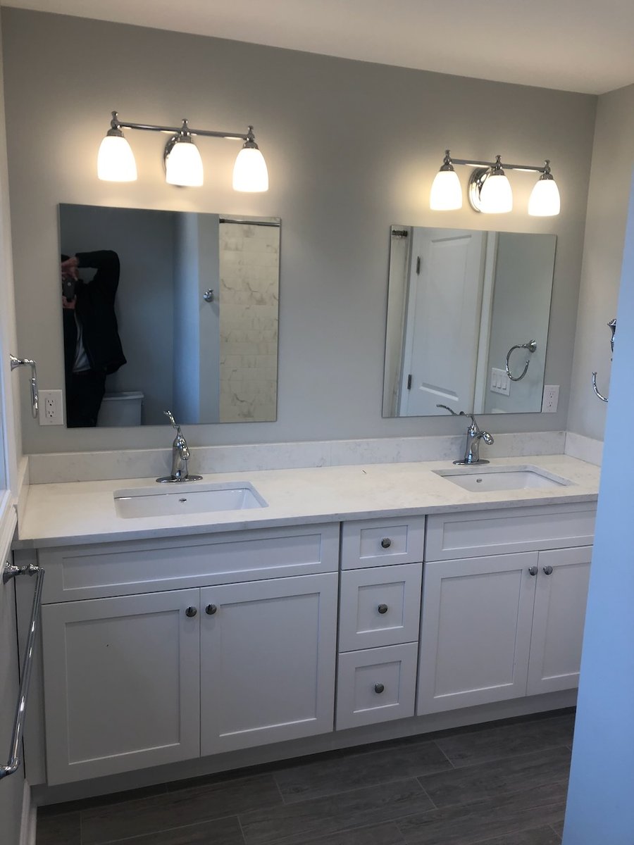 Dual-sink vanity with white cabinets in Ridgewood, NJ custom home by Fairmount Heights Homes.