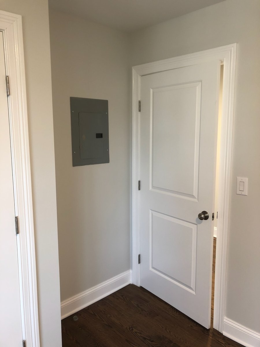 Electrical panel and white door inside a custom home built in Ridgewood by Fairmount Heights Homes.
