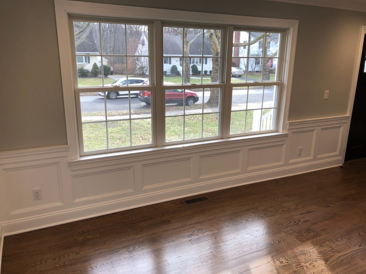 Large window with detailed trim and paneling in a custom Ridgewood, NJ home by Fairmount Heights Homes.