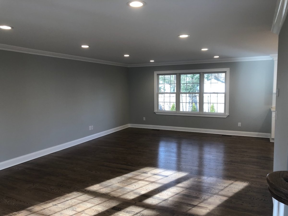Living room with large window, hardwood floors, and recessed lighting in Ridgewood custom home.