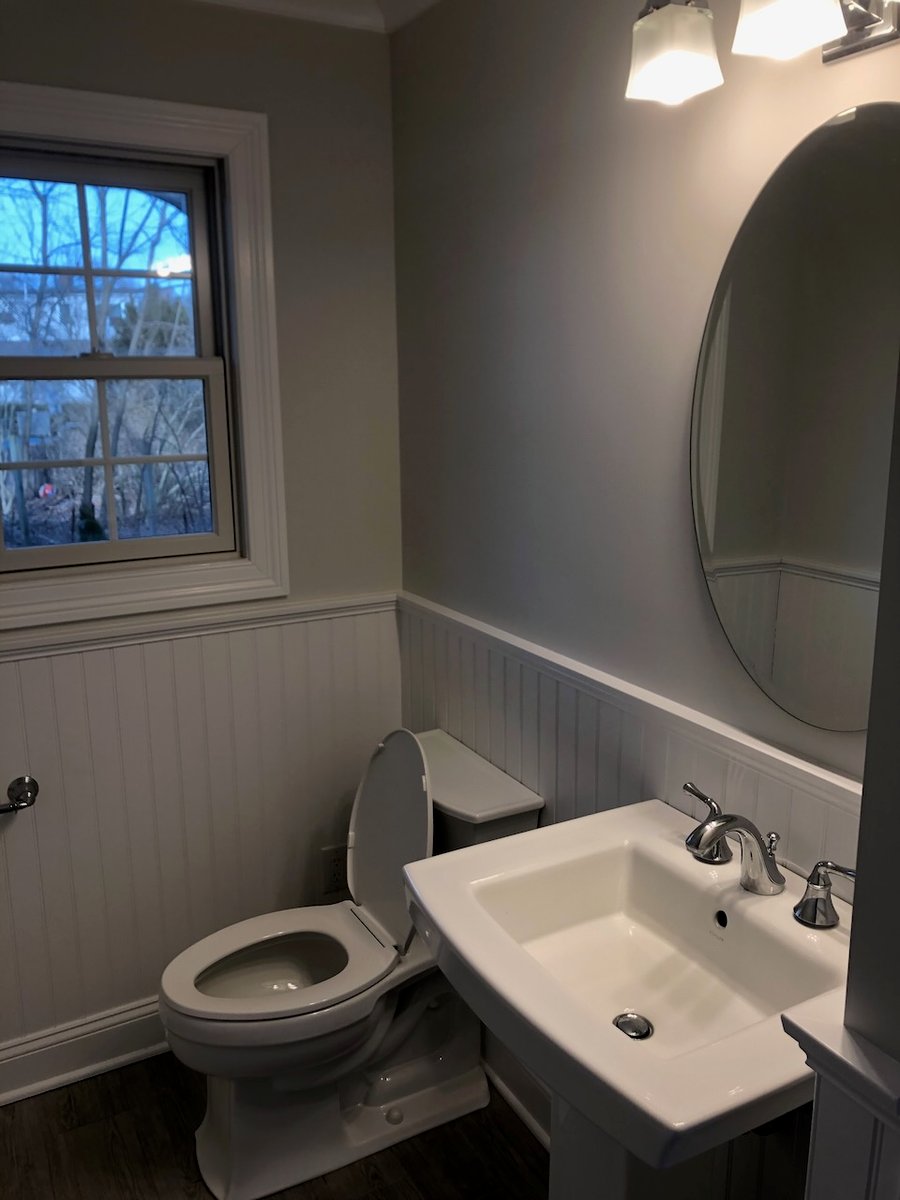 Modern half bathroom with pedestal sink and beadboard wainscoting in Ridgewood, NJ.