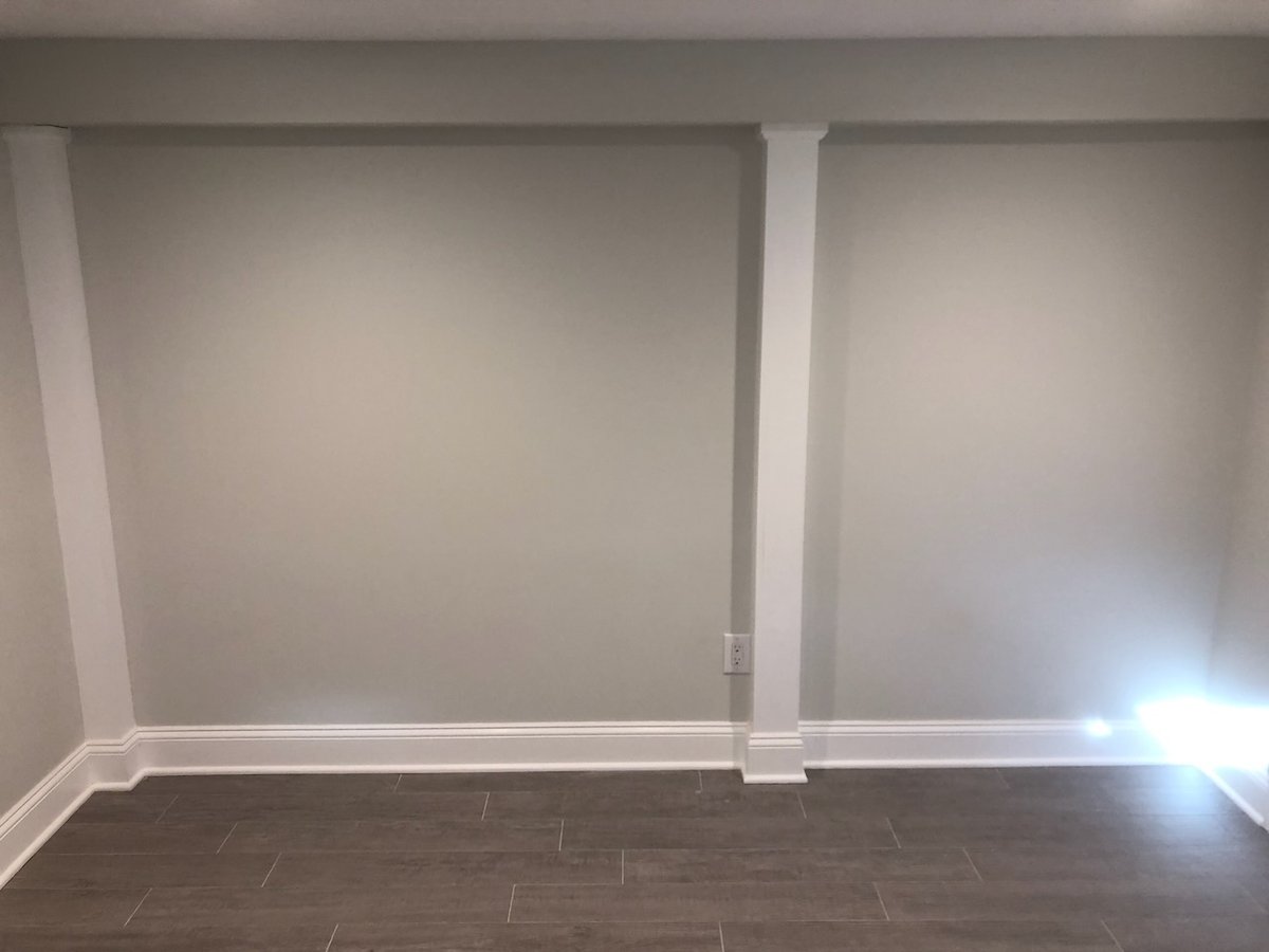 Neutral painted basement wall with columns in custom home by Fairmount Heights Homes in Ridgewood.
