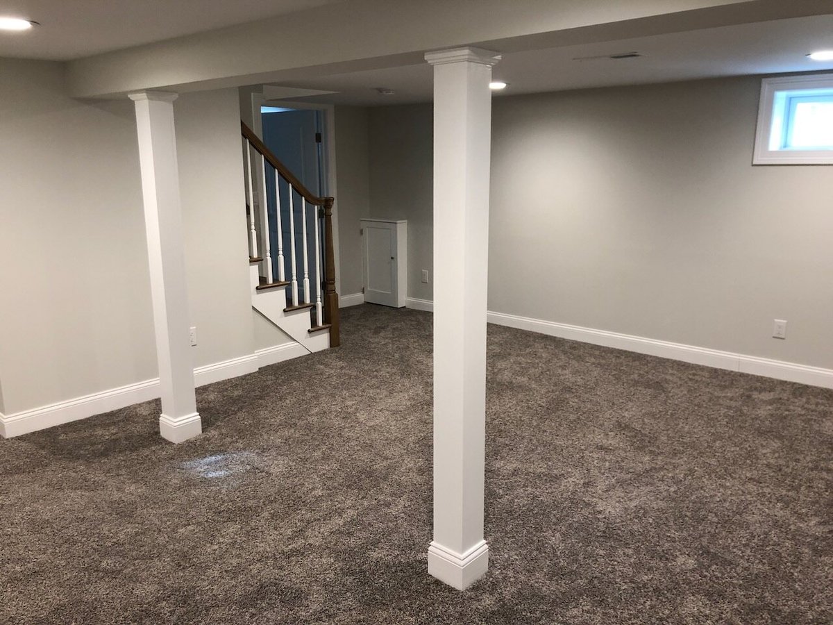 Open basement layout with support columns and stair access in Ridgewood home by Fairmount Heights Homes.