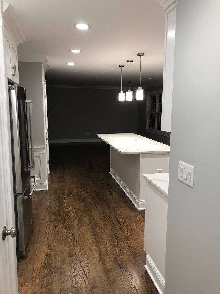 Open-concept kitchen with wood floors and large island by Fairmount Heights Homes in Ridgewood, NJ.