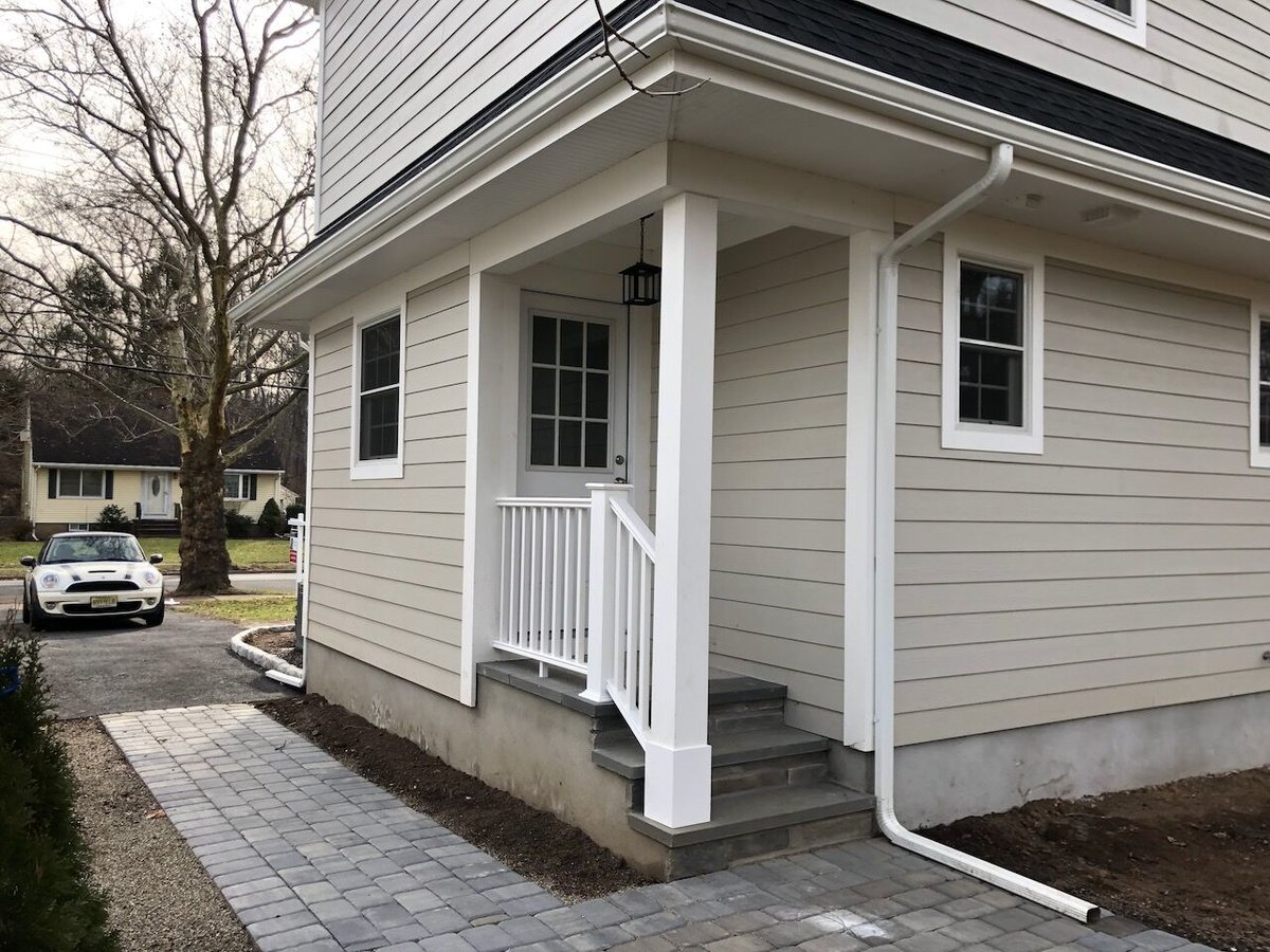 Rear view of custom home entryway and paver walkway in Ridgewood, NJ by Fairmount Heights Homes.