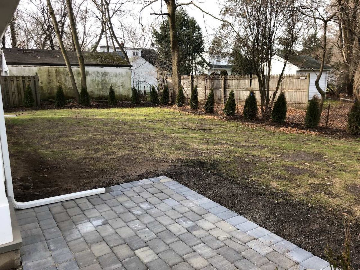 Spacious backyard with privacy trees and fencing behind a custom home in Ridgewood, NJ by Fairmount Heights Homes.