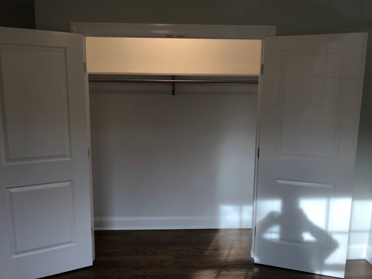 Spacious closet interior with hanging rod in custom Ridgewood home by Fairmount Heights Homes.