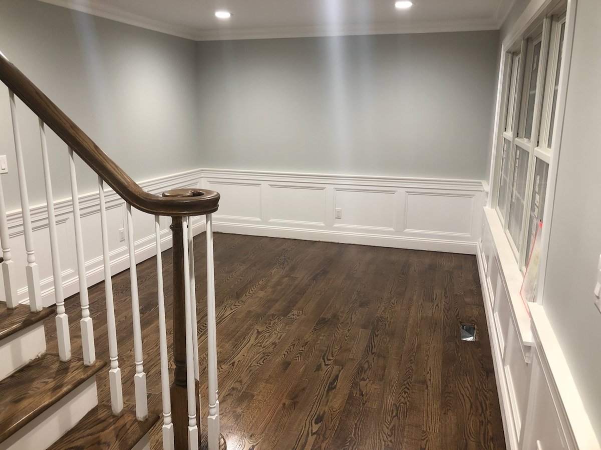 Stair landing with white wainscoting and oak floors in Ridgewood, NJ custom home.