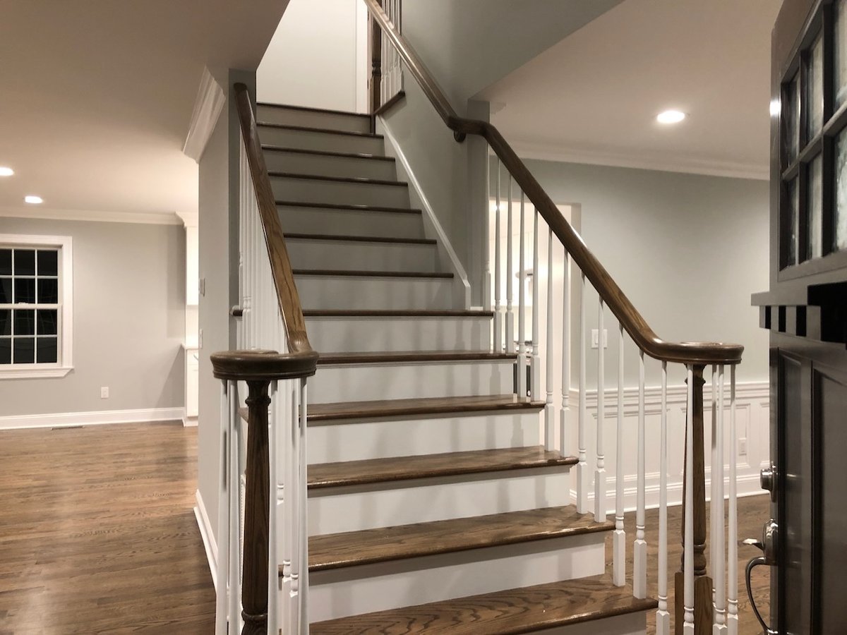 Staircase with stained wood treads and white risers in Ridgewood custom home by Fairmount Heights Homes.