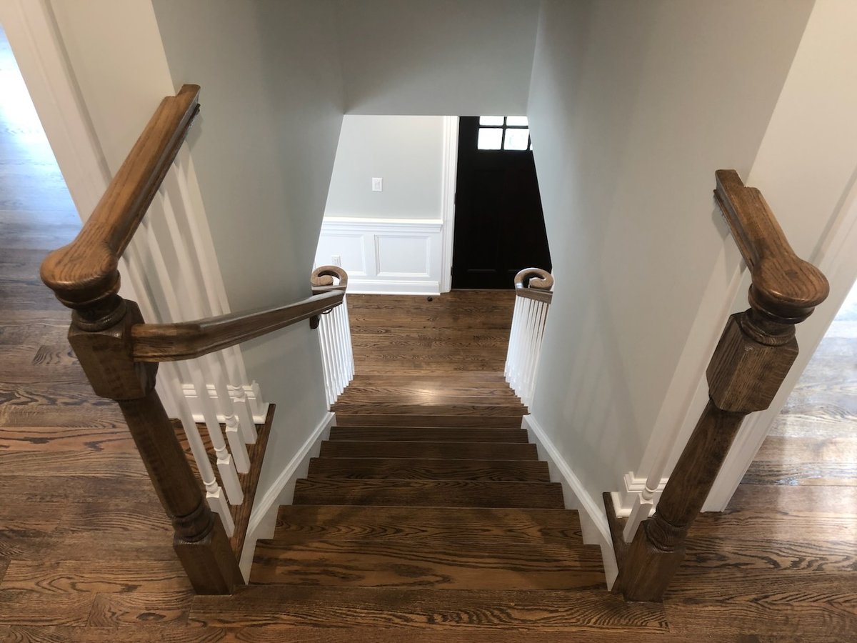 Traditional staircase with wooden banisters in Ridgewood custom home by Fairmount Heights Homes.