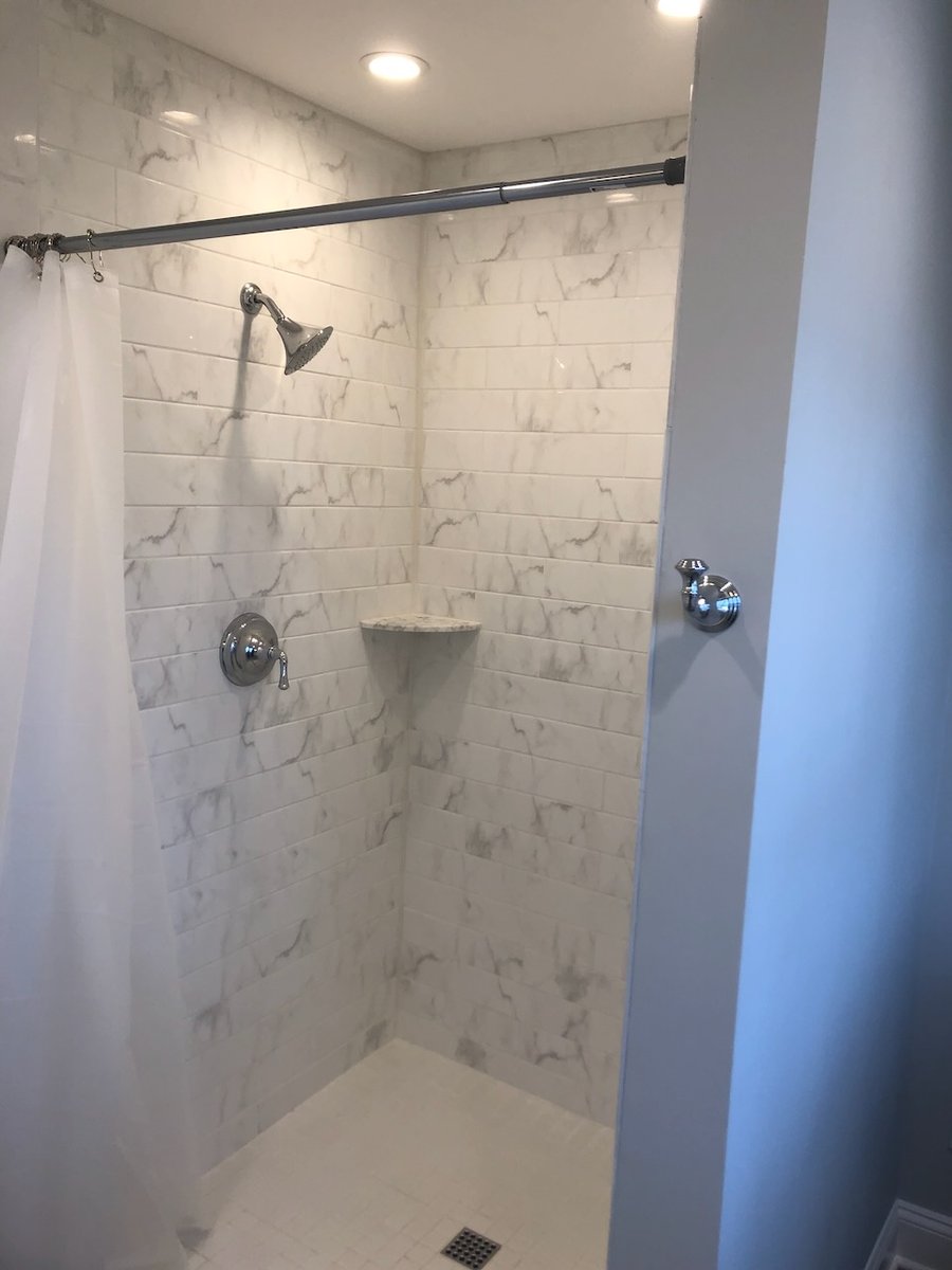 Walk-in shower with marble-style tile in Ridgewood, NJ custom home by Fairmount Heights Homes.