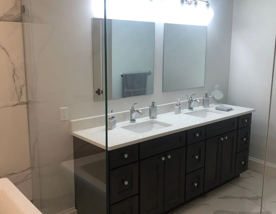 Bathroom vanity with double mirrors and chrome fixtures in a Ridgewood, NJ home by Fairmount Heights Homes