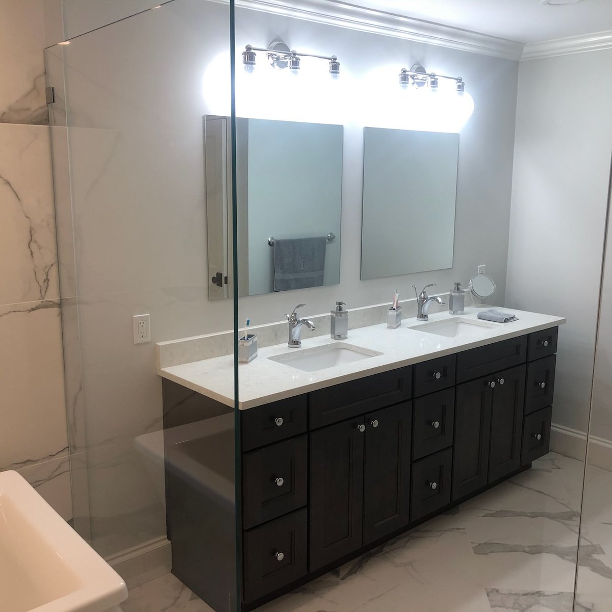 Bathroom vanity with double mirrors and chrome fixtures in a Ridgewood, NJ home by Fairmount Heights Homes.