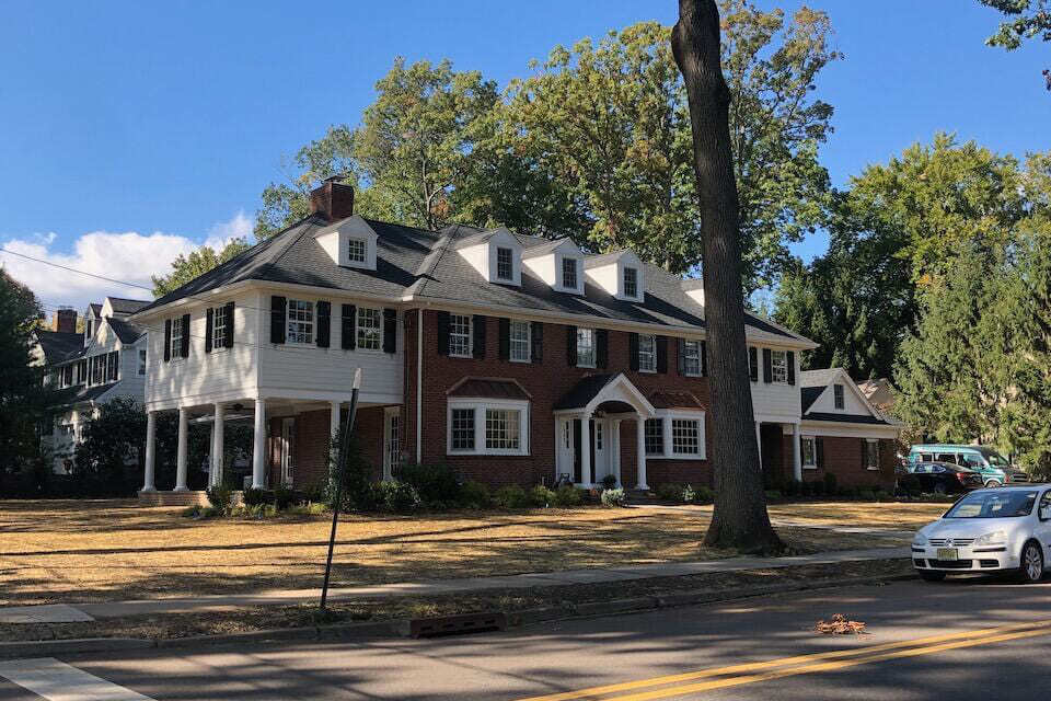 Brick and siding custom home with dormers and black shutters in Ridgewood, NJ by Fairmount Heights Homes
