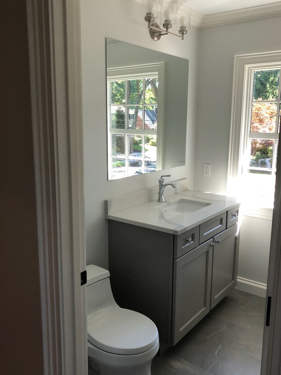 Bright bathroom with gray vanity, quartz countertop, and natural light in Ridgewood, NJ by Fairmount Heights Homes.