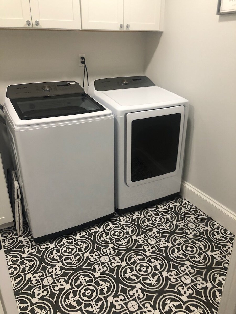 Dual appliance laundry station with overhead cabinetry and patterned flooring in Ridgewood, NJ custom home by Fairmount Heights Homes.