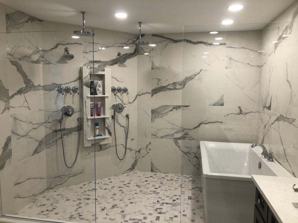 Luxury bathroom with double rain showerheads and freestanding tub in a Ridgewood, NJ custom home by Fairmount Heights Homes.