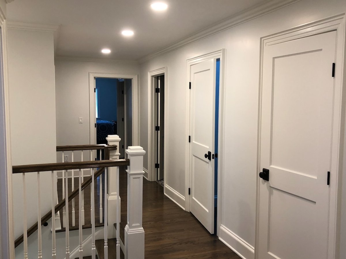 Upstairs hallway with white trim and hardwood flooring in a Ridgewood, NJ custom home by Fairmount Heights Homes.
