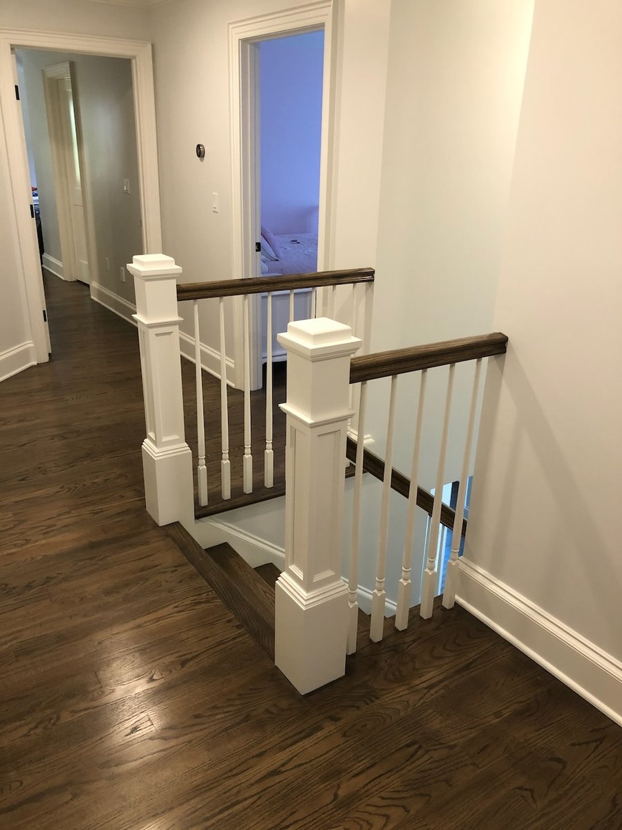 Upstairs stair landing with wood floors and white railing in Ridgewood, NJ custom home by Fairmount Heights Homes.
