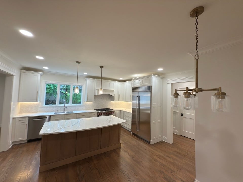 Custom kitchen with marble island, pendant lighting, and stainless appliances in Ridgewood, NJ by Fairmount Heights Homes