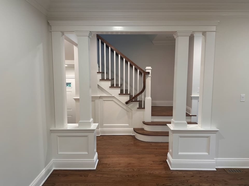 Front view of staircase framed by decorative columns in Ridgewood custom home by Fairmount Heights Homes.