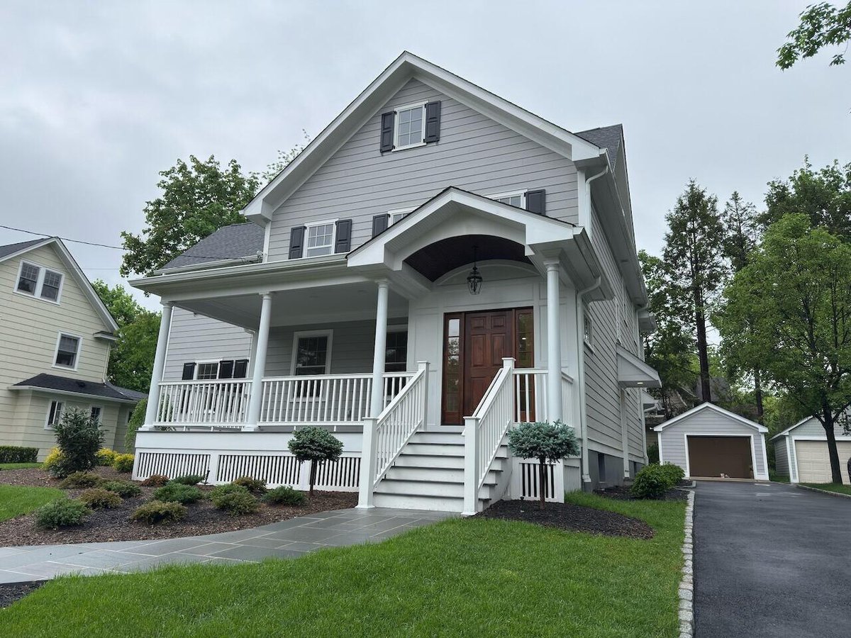 Front angled view of Ridgewood, NJ custom home with porch and stone path by Fairmount Heights Homes