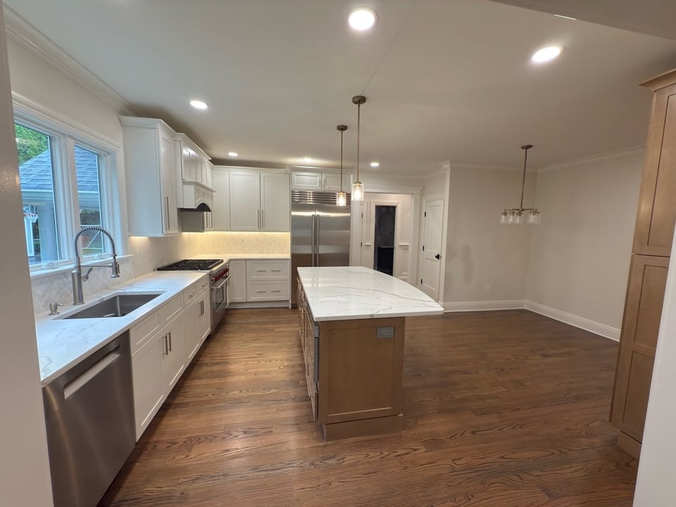 Spacious kitchen with farmhouse sink, quartz countertops, and pendant lights by Fairmount Heights Homes in Ridgewood, NJ