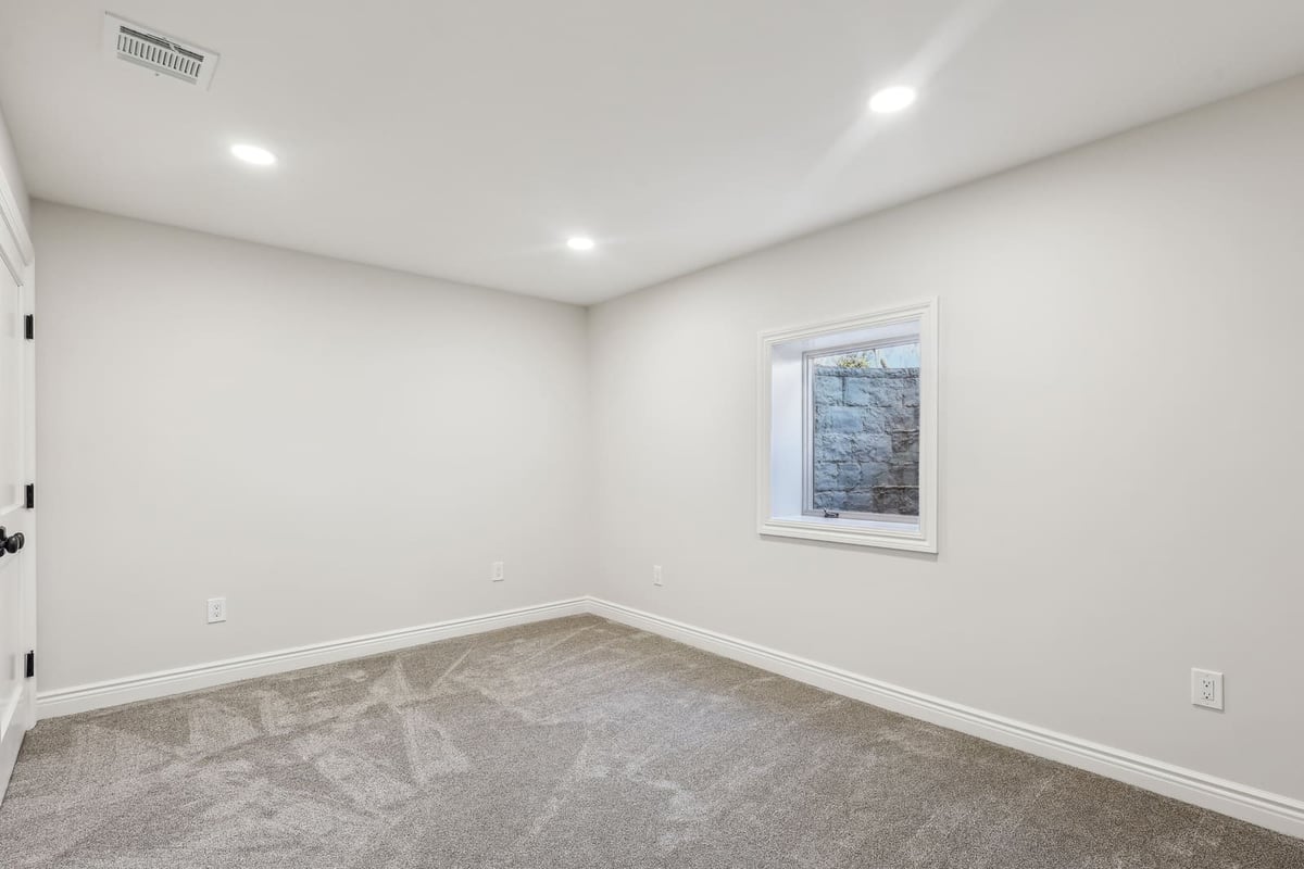 Basement bedroom in Ridgewood, NJ with egress window and recessed lights