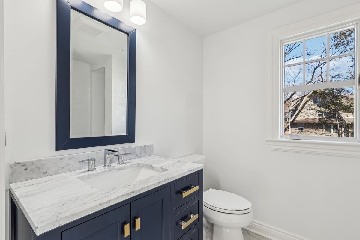 Bathroom in Ridgewood, NJ with navy vanity and marble countertop