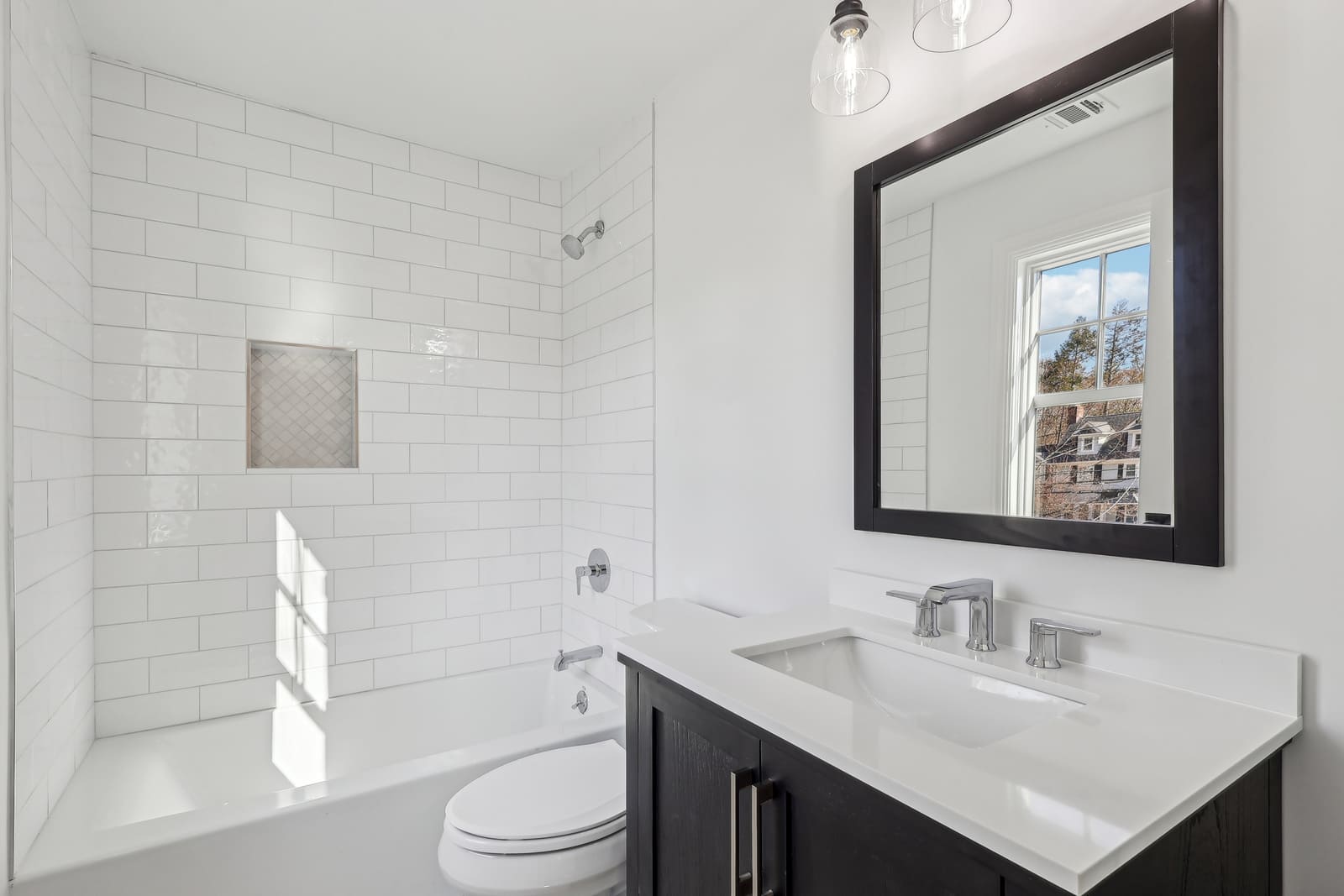 Bathroom in Ridgewood, NJ with white subway tile tub and dark vanity