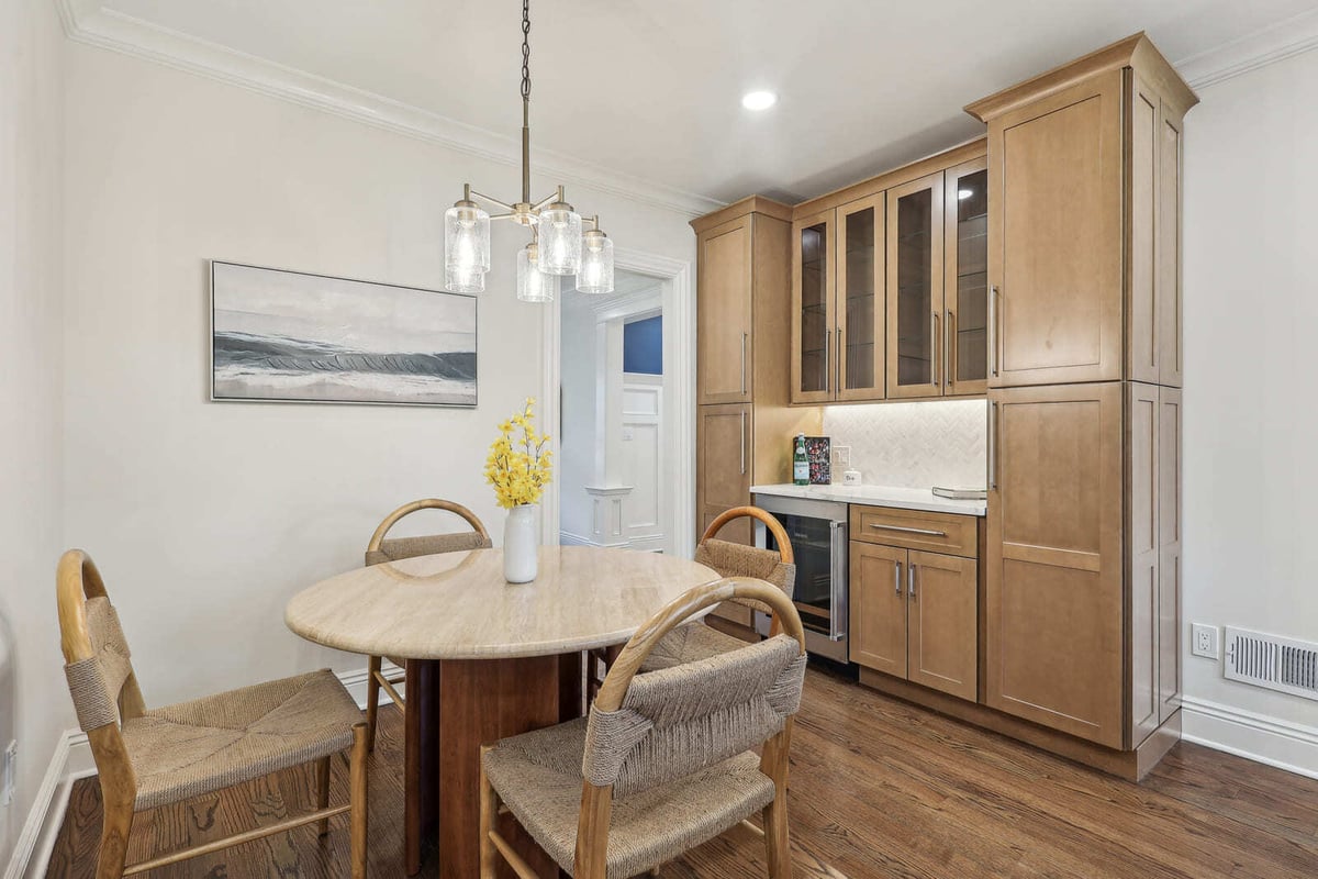 Breakfast nook in Ridgewood, NJ with round table, woven chairs, and built-in cabinetry