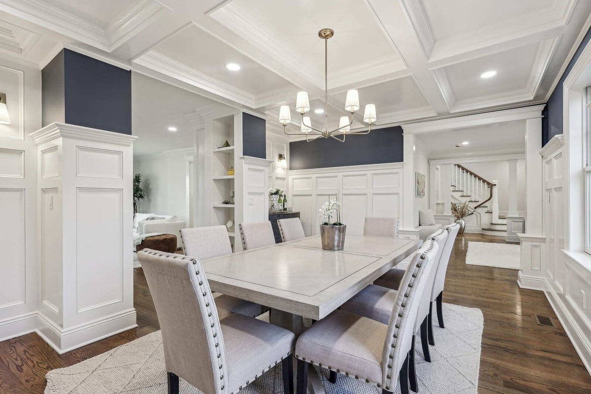 Elegant dining room in Ridgewood, NJ with paneled walls, chandelier, and open layout