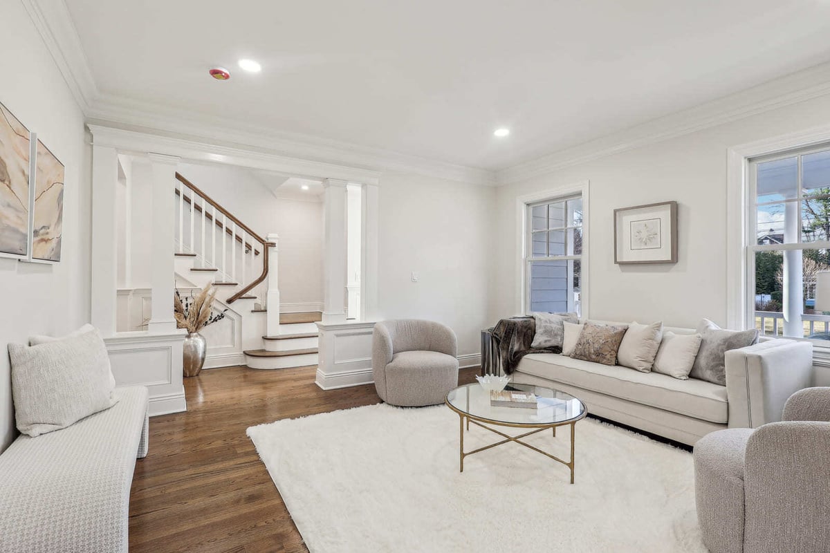 Elegant living room in Ridgewood, NJ with hardwood floors, staircase, and soft neutral decor