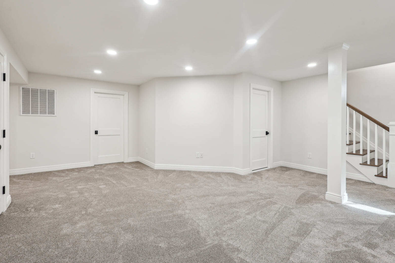 Finished basement in Ridgewood, NJ with carpet, recessed lighting, and stair access