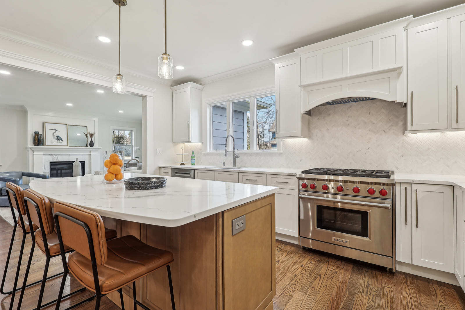 Modern kitchen in Ridgewood, NJ with large island, Wolf range, and white cabinetry