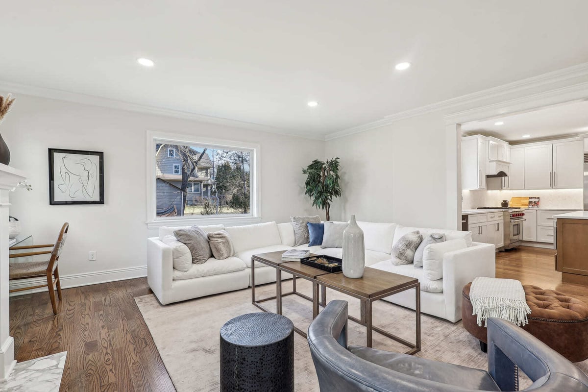 Open living area in Ridgewood, NJ with sectional sofa, hardwood floors, and view into kitchen