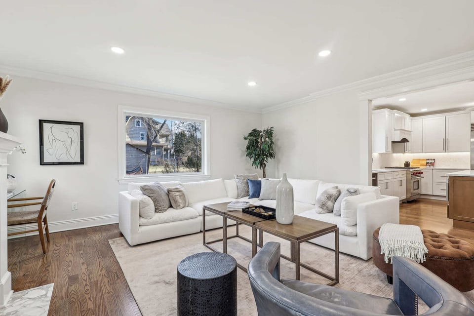 Open living area in Ridgewood, NJ with sectional sofa, hardwood floors, and view into kitchen
